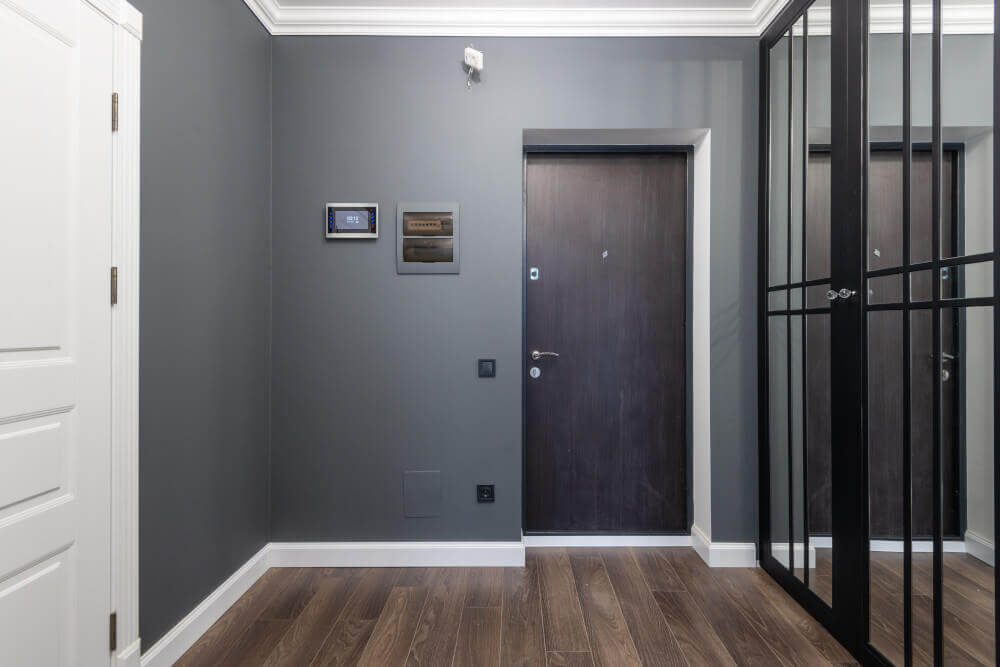 Интериорен дизайн на коридор в сиво с тъмен под и бели первази
